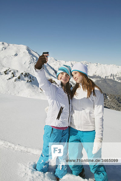 Two teenage girls in ski clothes  taking self portrait