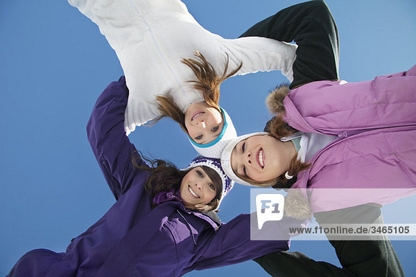 Drei Teenagermädchen in Skikleidung  lächelnd vor der Kamera