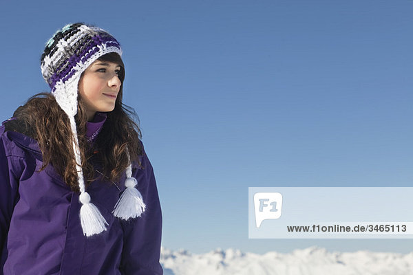 Teenage girl in ski-wear day dreaming