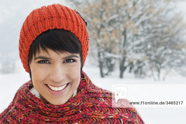Junge Frau in Winterkleidung lächelnd vor der Kamera