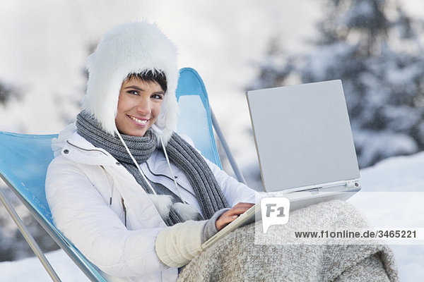 Young woman using laptop computer in snow