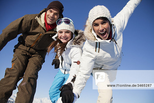 Couple and daughter in ski wear smiling at camera