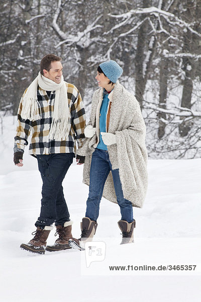 Young couple looking at each other,  walking in snow