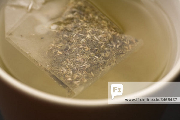 Detail of a teabag in a cup of water