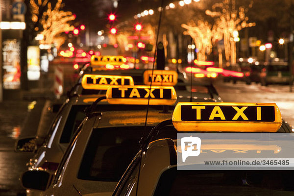 Detail der nachts in einer Reihe geparkten Taxis