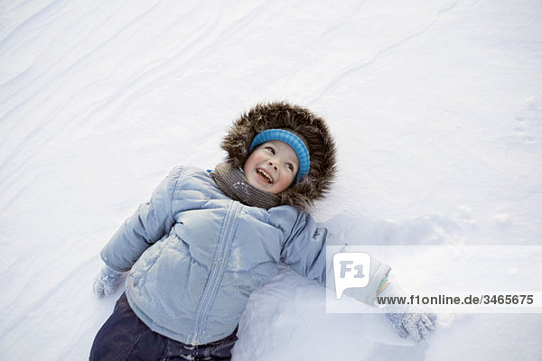 Ein Junge spielt im Schnee