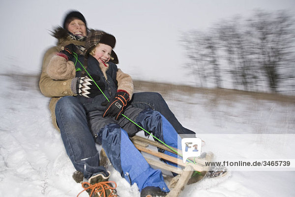 A mother and her son sledding