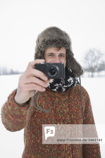 A man taking a picture with a digital camera  outdoors  portrait