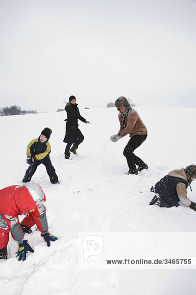 A family of five having a snowball fight