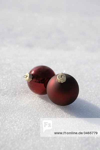 Two Christmas ball ornaments on the snow
