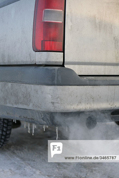 A car exhaust pipe emitting fumes