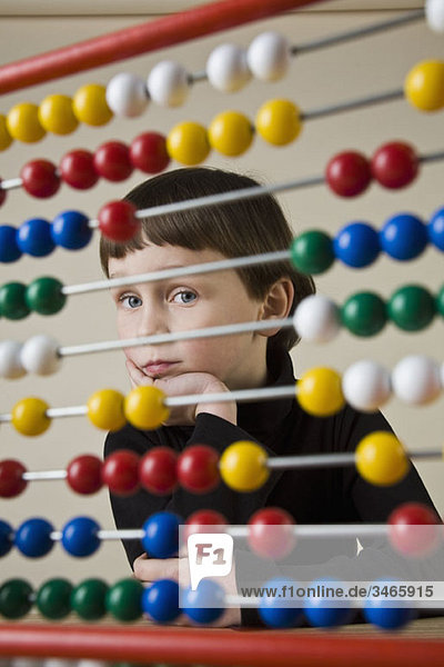 A boy looking through an abacus