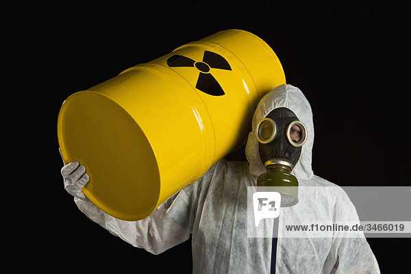 Eine Person  die einen radioaktiven Lauf trägt und Schutzkleidung trägt.