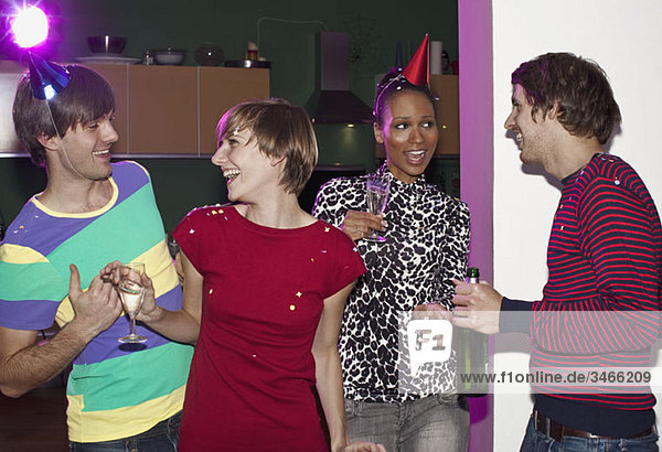 Vier Freunde beim Feiern mit Konfetti und Champagner