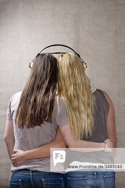 Teenagerinnen teilen sich Kopfhörer