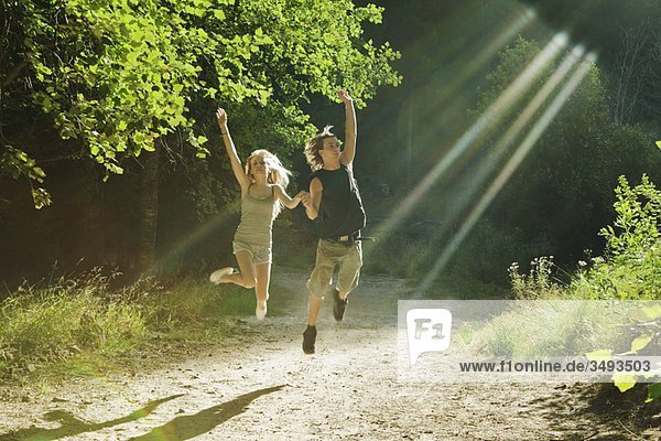 Young couple jumping in forest