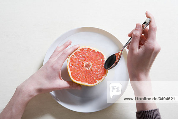 Junge Frau beim Grapefruitessen