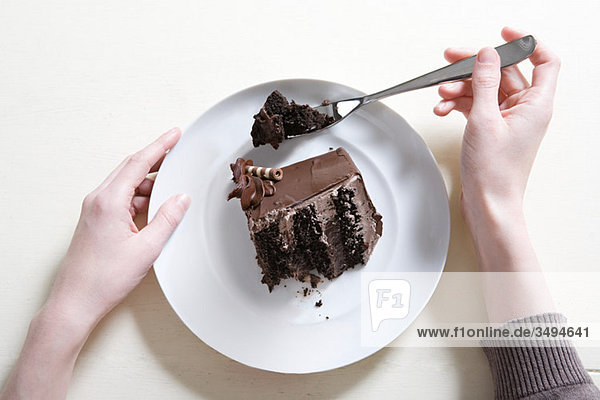 Junge Frau isst Schokoladenkuchen