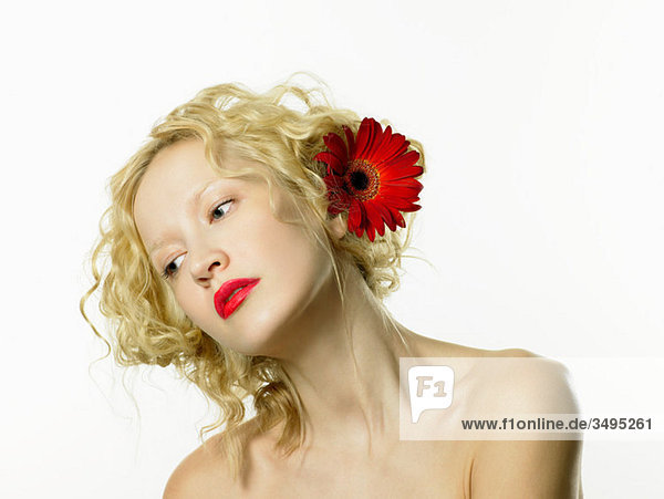 Junge Frau mit roter Blume im Haar