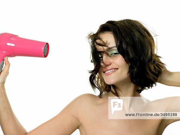 Young woman using hairdryer