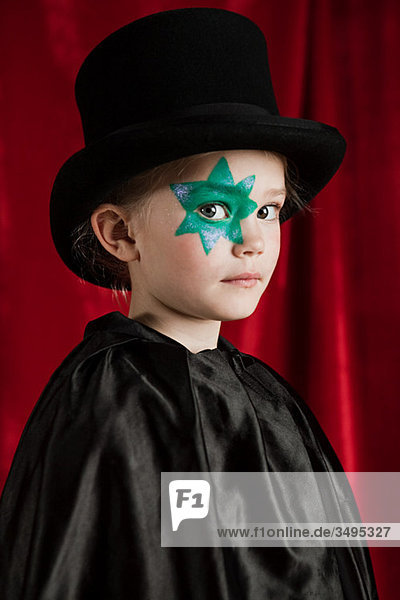 Young girl dressed up as magician wearing top hat
