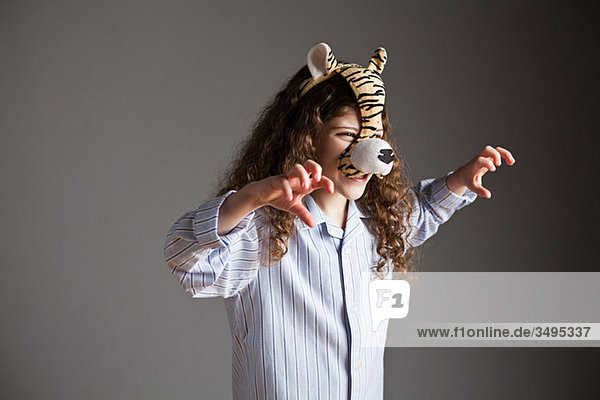 Junges Mädchen mit Tigermaske  brüllend
