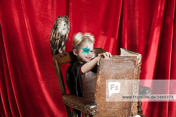 Young girl dressed up as wizard reading spell book