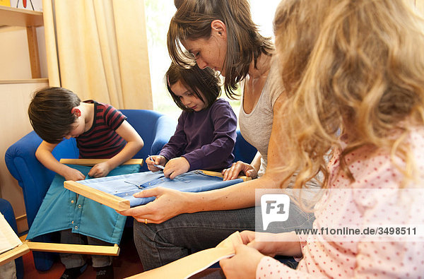 Kindergärtnerin und Kinder spielen mit Verschlussrahmen