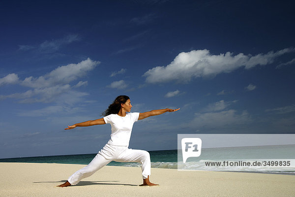 Frau macht Yoga am Strand  Paradise Island  Bahamas  Seitenansicht
