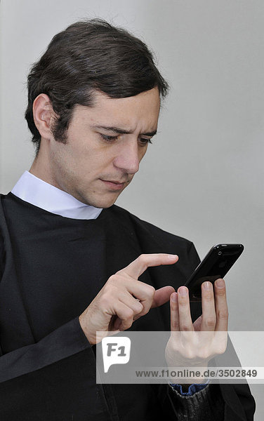 Junge Priester mit mobile