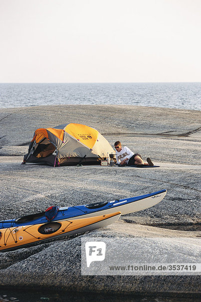Tent and kayaks on a rocky islet  Sweden