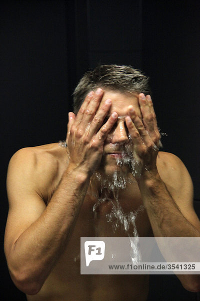 Mann wäscht sich das Gesicht