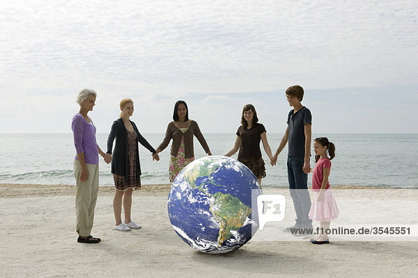 Ökologiekonzept  Gruppe von Menschen  die Händchen halten  um den Planeten Erde herumstehen