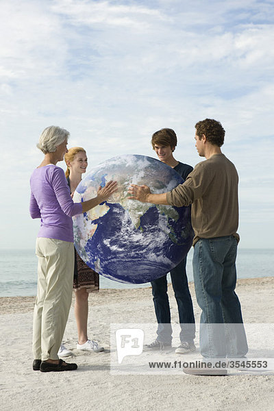 Ökologiekonzept  vier Menschen legen gemeinsam die Hände auf die Erde