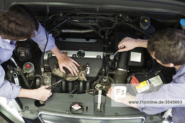 Mechanics reparing car engine