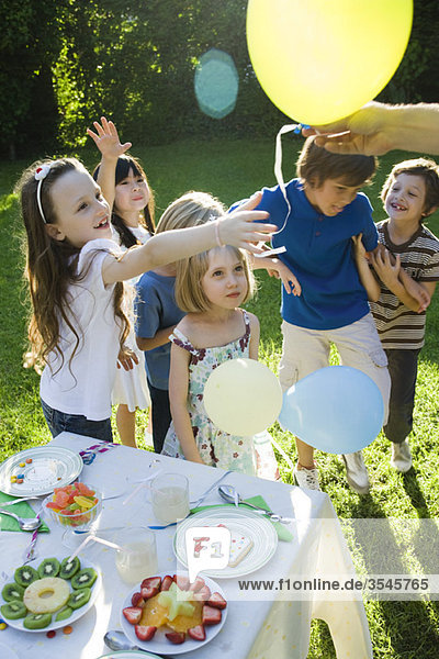 Verteilen von Luftballons bei der Kindergeburtstagsfeier