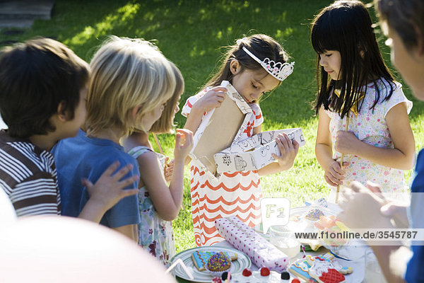 Mädchen Eröffnungsgeschenk bei der Geburtstagsfeier als Freunde ansehen