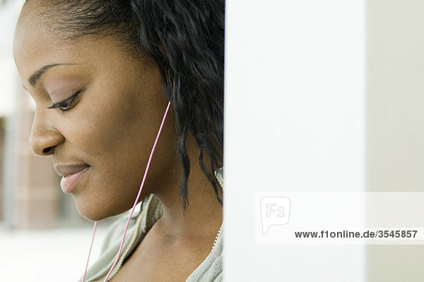 Young woman listening to MP3 player
