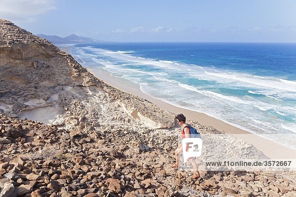 Frau wandert an Felsküste spazieren Jandia Fuerteventura Spanien