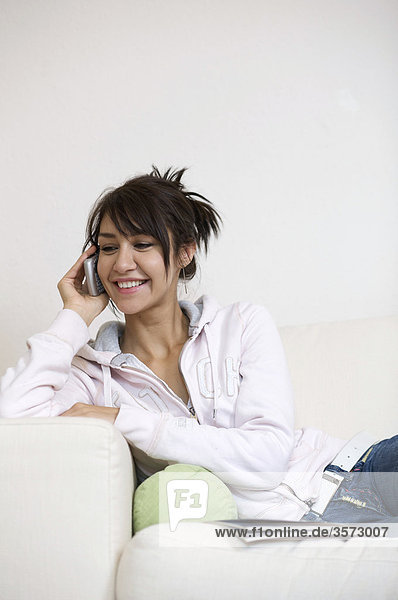Happy woman in living room on the phone