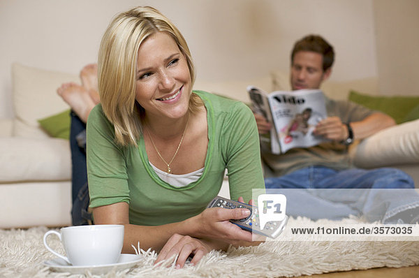 Couple at home with remote control and magazine