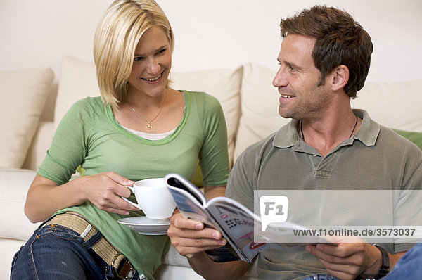 Relaxed couple at home with magazine and coffee