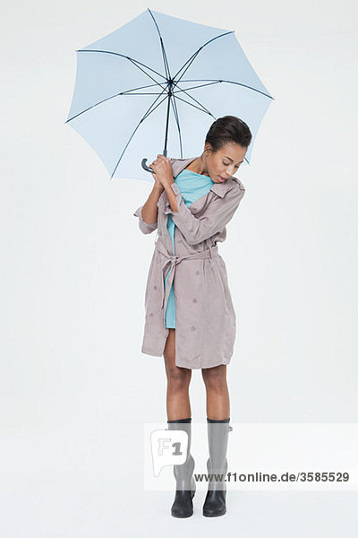 Junge Frau mit Regenschirm und Blick nach unten