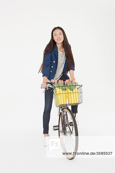 Fahrradfrau mit Blumen im Korb
