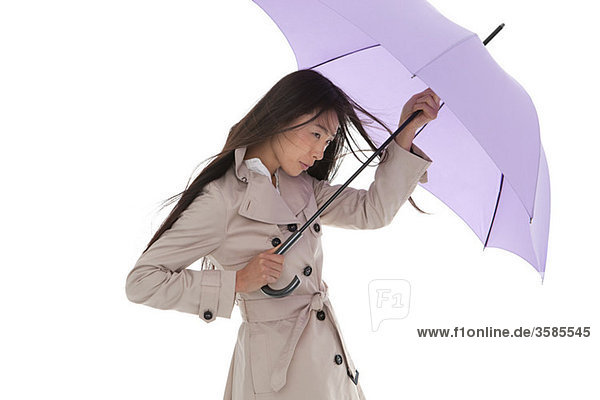 Frau mit Regenschirm im Wind