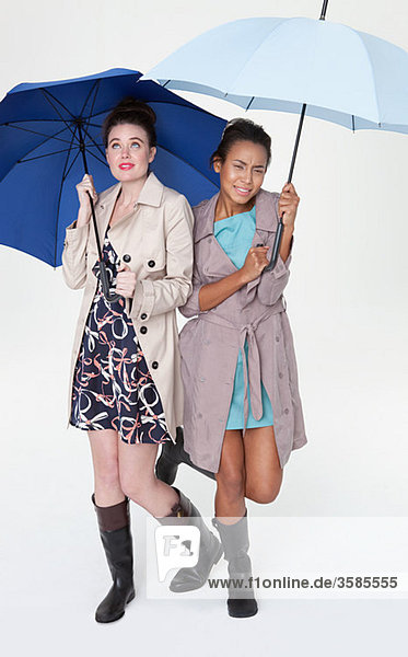 Junge Frauen unter Regenschirmen