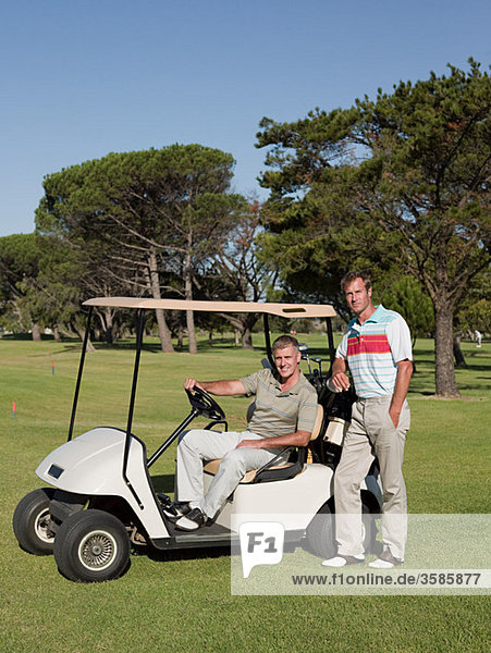 Zwei reife Männer im Golfwagen auf dem Golfplatz