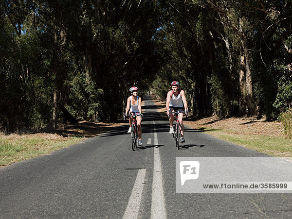 Young couple cycling on road