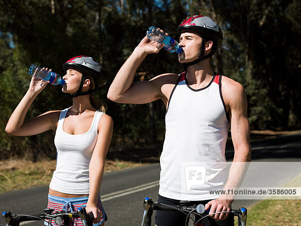 Young couple cycling on road
