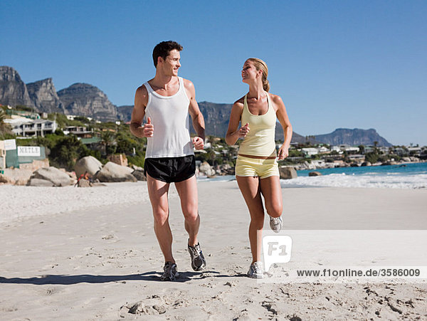 Young couple jogging on beach